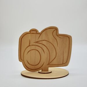 Krásny drevený kúsok v tvare fotoaparátu, ktorý elegantne ukáže, kde nájdete fotografa počas svadobnej hostiny.
